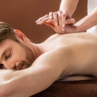 Young Man Receiving Back Massage At Spa