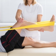 Physiotherapist Giving Treatment With Exercise Band